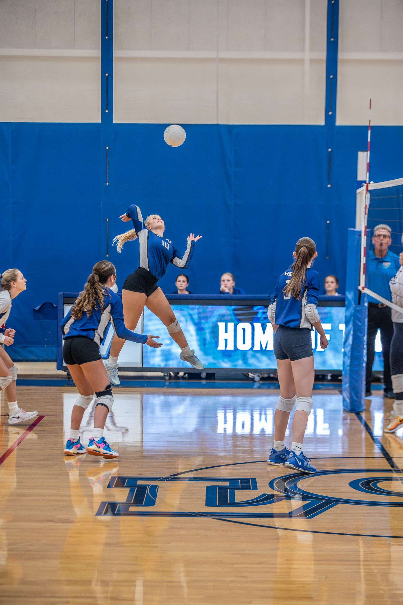 Volleyball player jumping to serve during a game